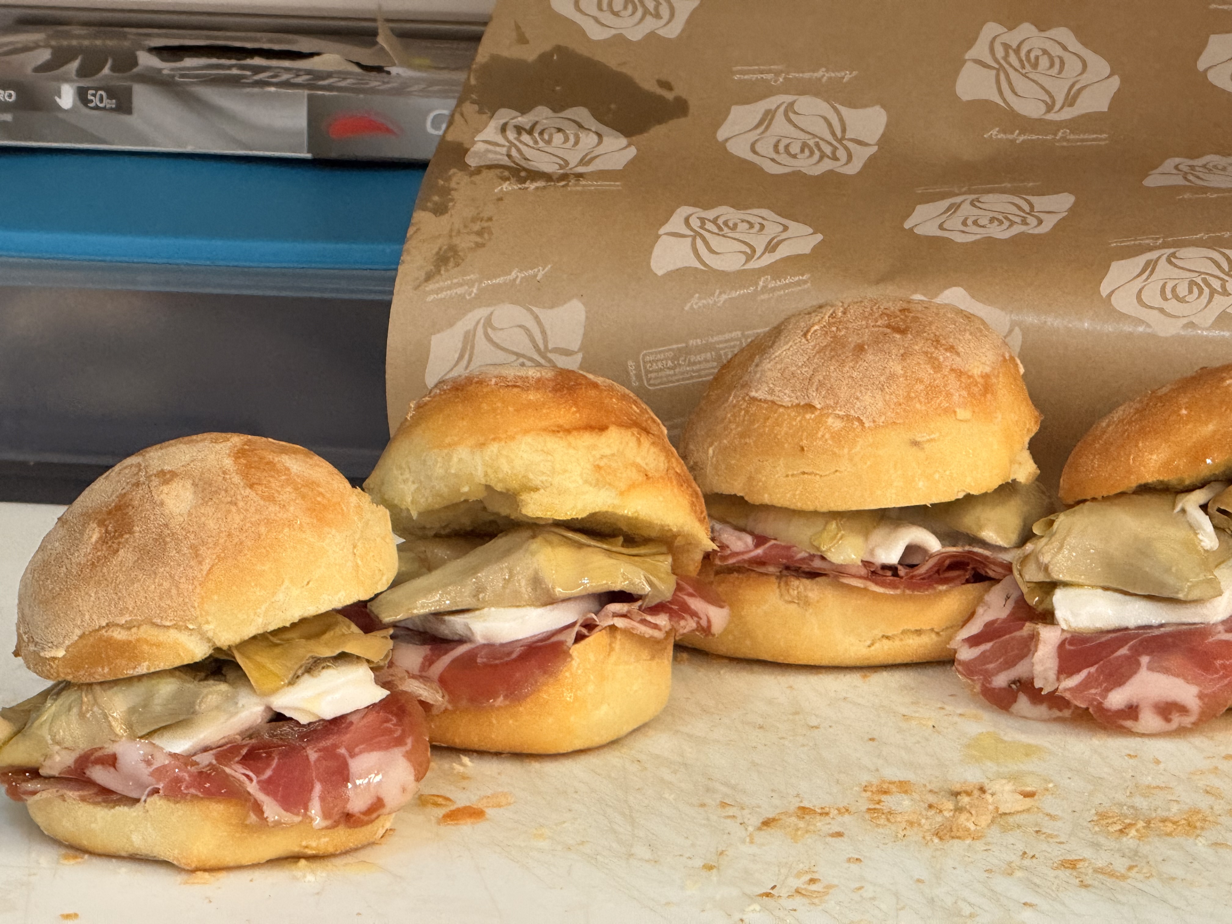 Rustic Puglian panini with local meats, fresh cheese, and olive oil on a farm table