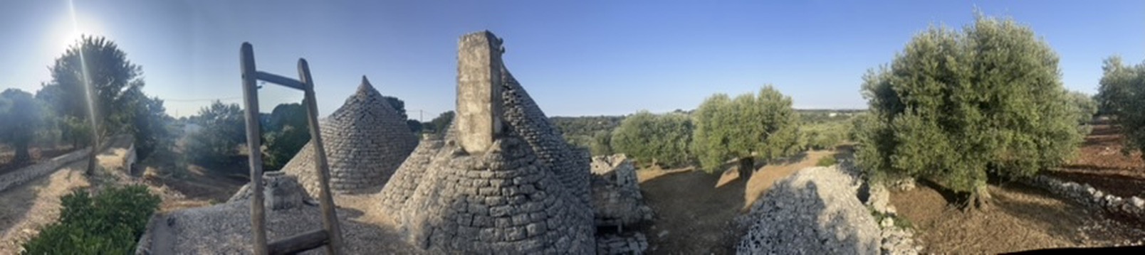Trullo rooftop panorama overlooking olive groves and landscape