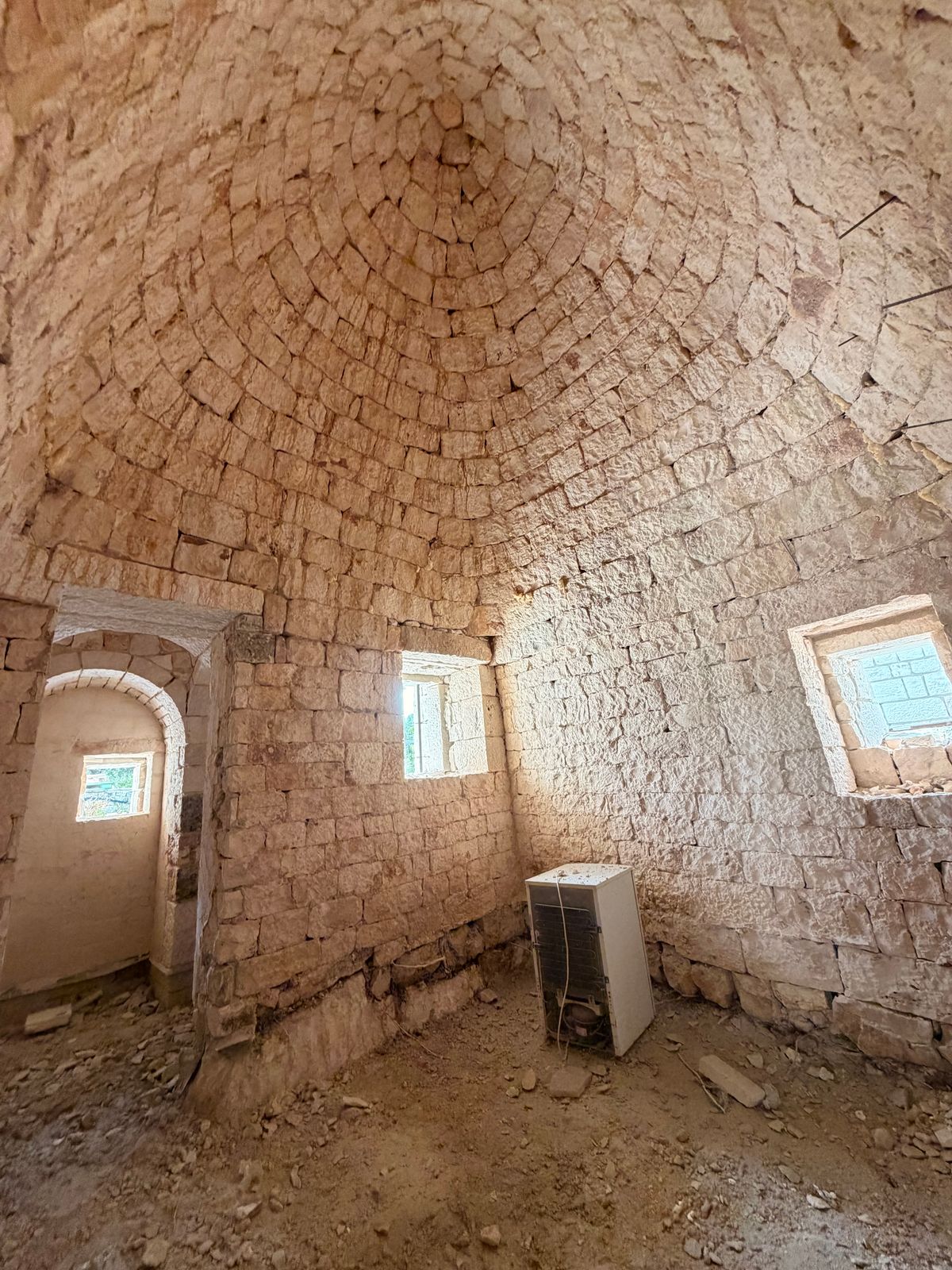Interior stone room with an arched window and freshly laid floor